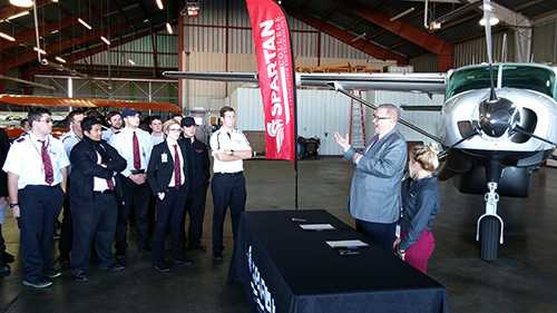 Spartan Students in front of booth and airplane