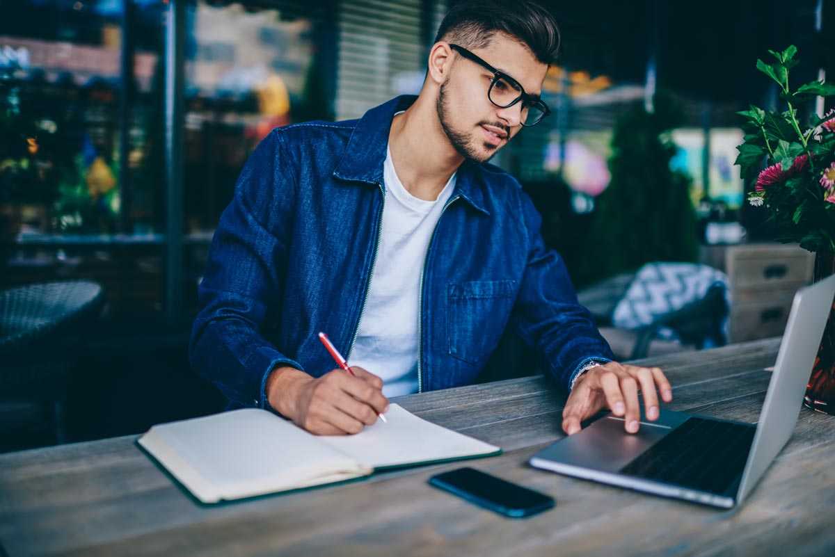 Spartan College - Bachelors Program - Man studying with book and laptop