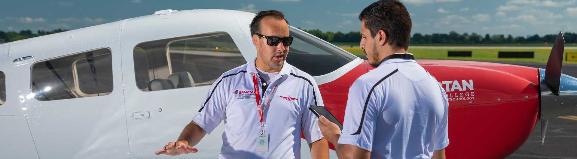 Spartan College flight instructor with student in front of plane horizontal