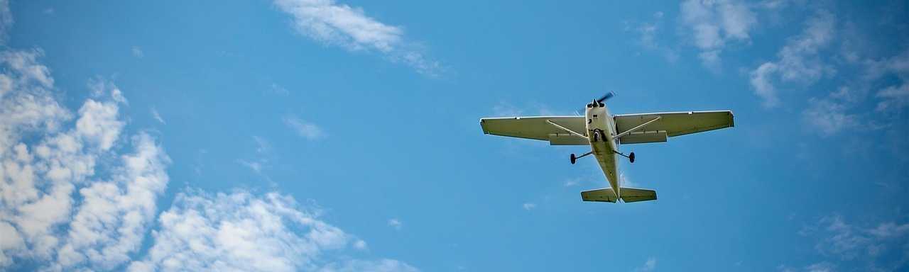 Plane in Flight behind blue sky