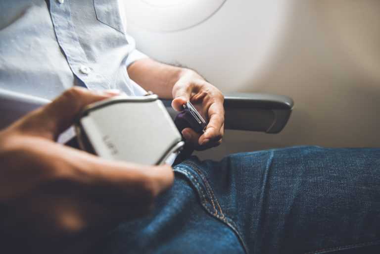 Passenger fastening seat belt while sitting on the airplane for a safe flight