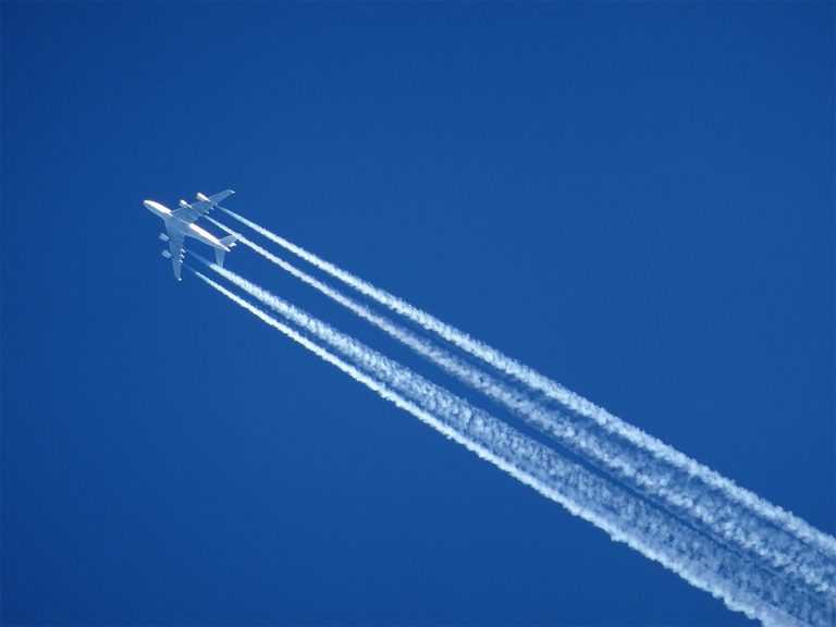 contrails on a plane in a blue sky