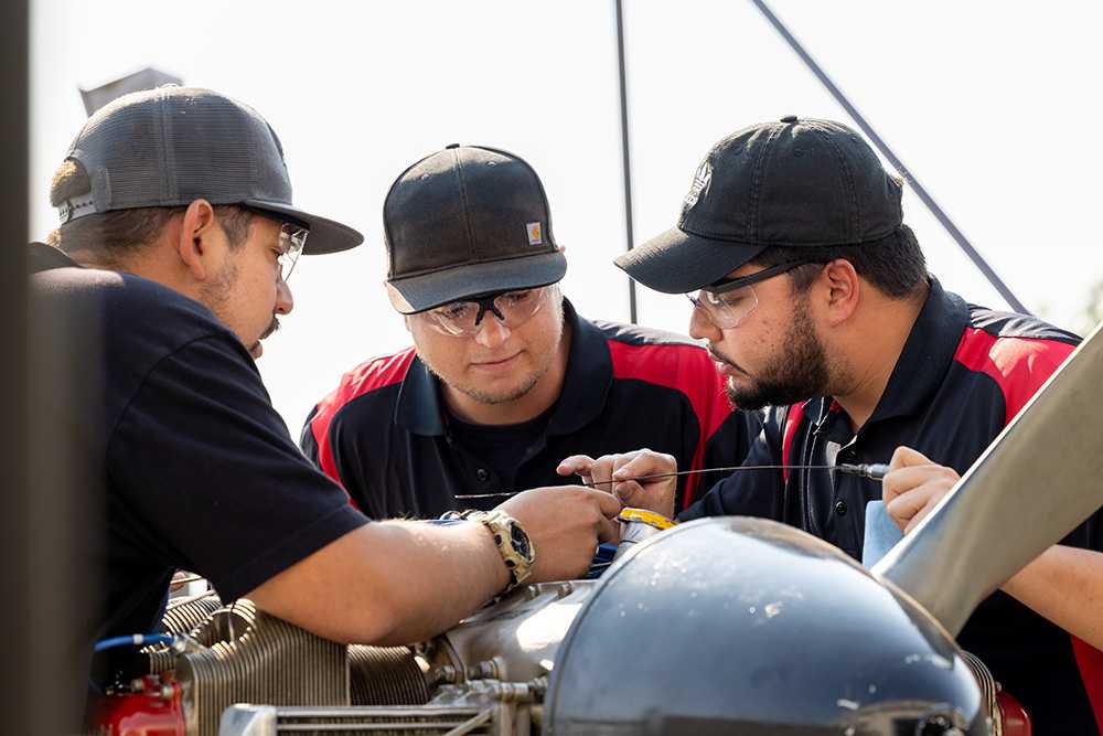 AMT Students working on engine with safety glasses on