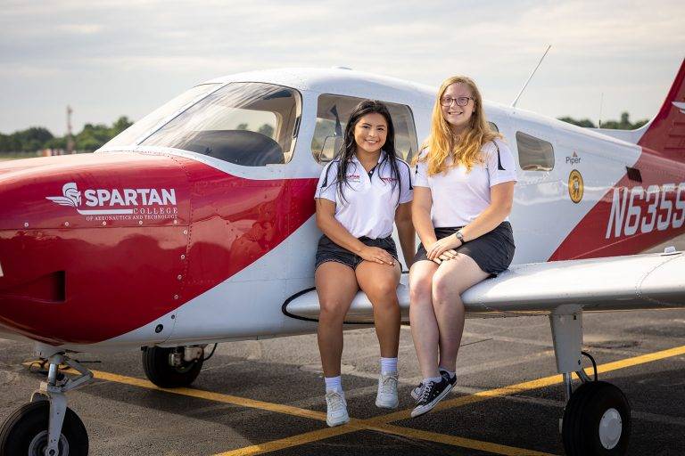 spartan students sitting on plane of new spartan piper archers