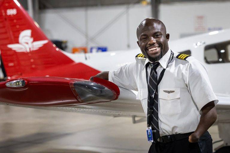 zack anglin in front of spartan college plane