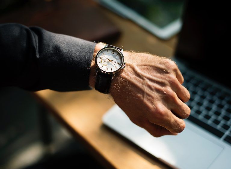 man looking at military wrist watch