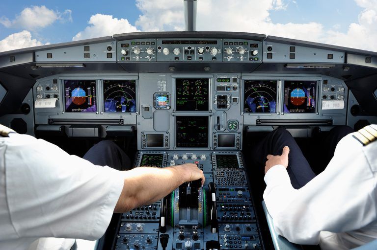 pilots in the cockpit of a commercial plane